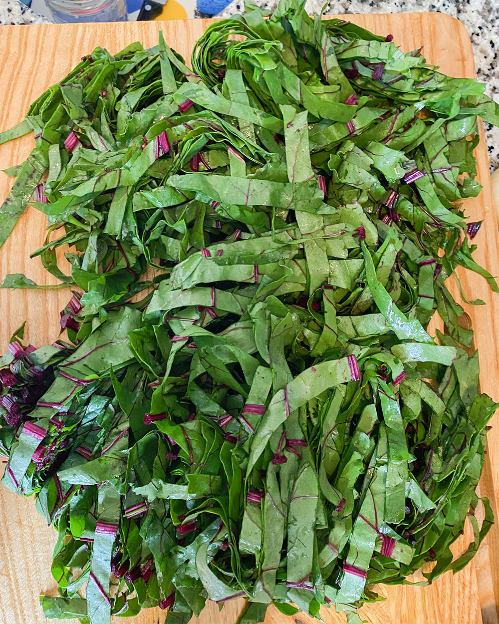 a cutting board with chopped greens