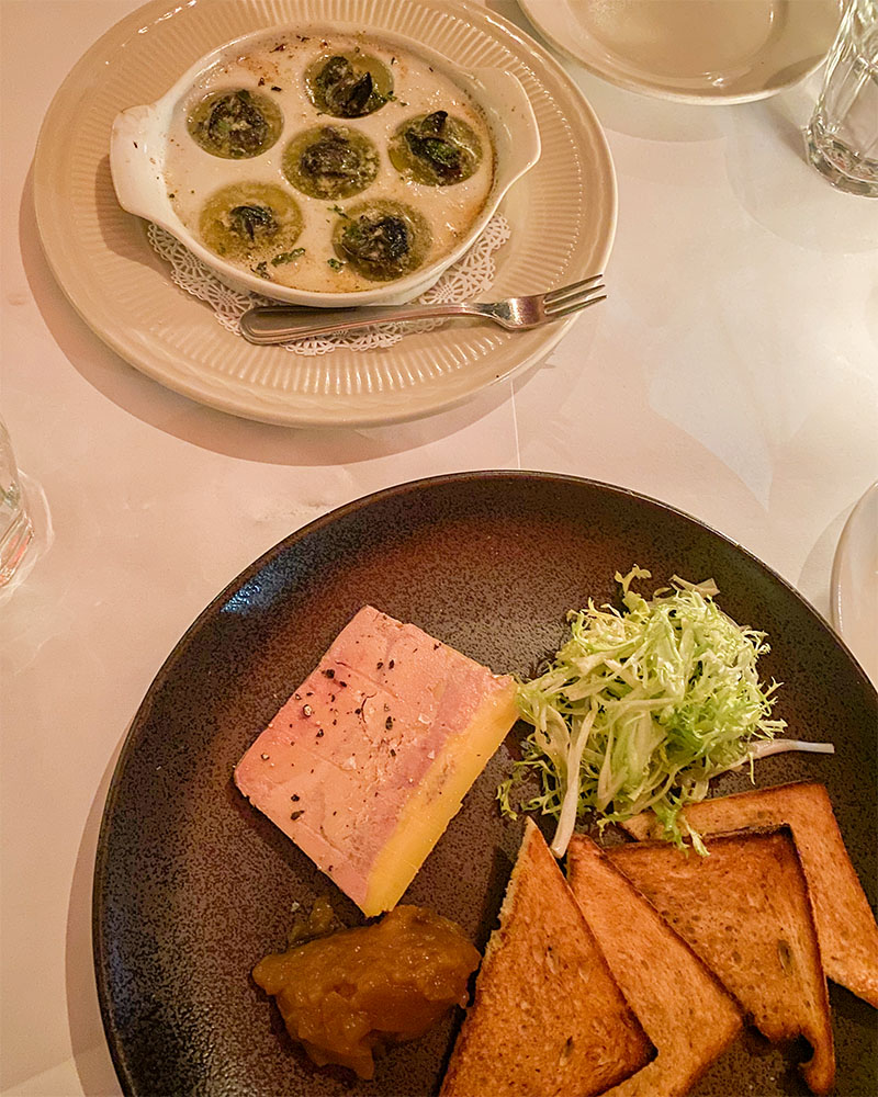 a dinner table with escargot and foie gras